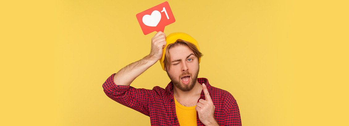 Instagrammer con Pose Divertida Mientras Señala Ícono de Me Gusta en su Cabeza
