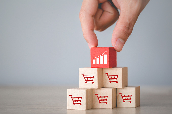 Pirmide de Bloques con Carritos de Compra con un Bloque Mostrando Grfico de Ventas en la Cima