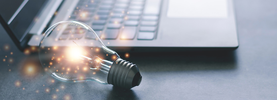 Bombillo Brillando Junto a Laptop para Representar el Éxito de Tácticas con Creadores de Contenido