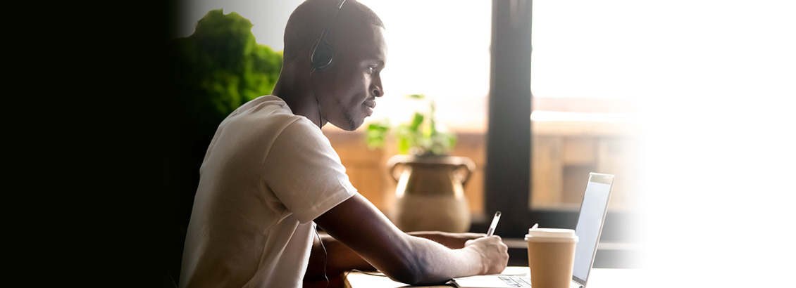 Emprendedor Frente a Laptop Tomando Notas para Aumentar la Visibilidad de Su Empresa en LinkedIn