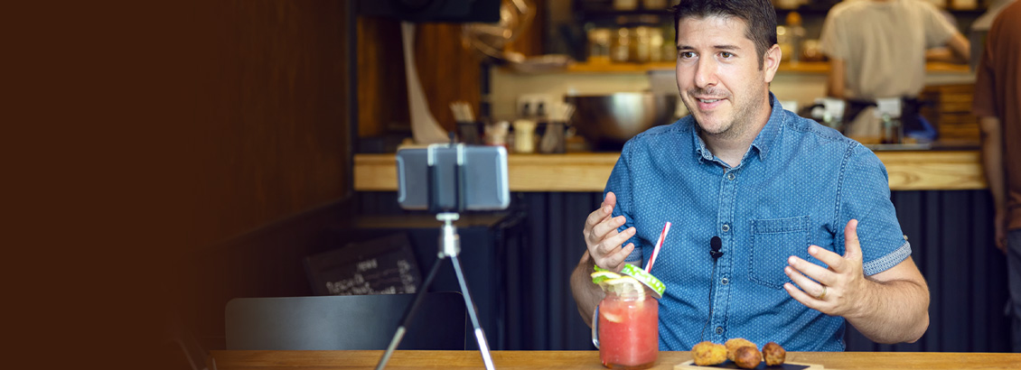 Dueño de Restaurante Grabando en su Teléfono Contenido Para sus Redes Sociales