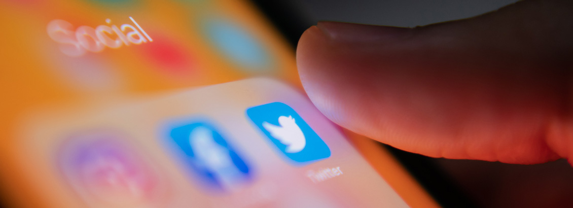 Dedo Pulsando Ícono de Twitter en Pantalla de Smartphone