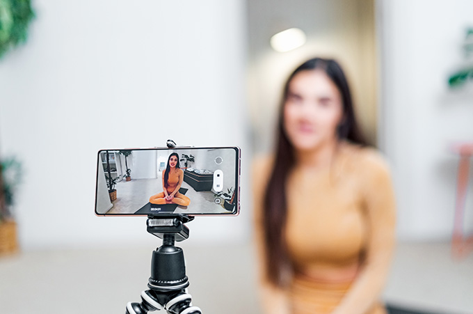 Mujer Sentada en el Suelo Grabando Video Frente a su Smartphone