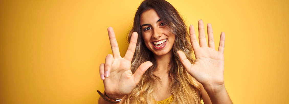 Mujer Joven y Sonriente Mostrando Ocho Dedos de su Manos