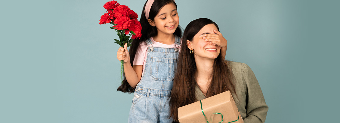 Niña Tapándole los Ojos a su Madre Mientras Sostiene un Ramo de Rosas