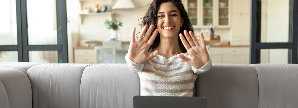Mujer Sonriente Sentada en Sofá Extendiendo Sus Manos Hacia el Frente