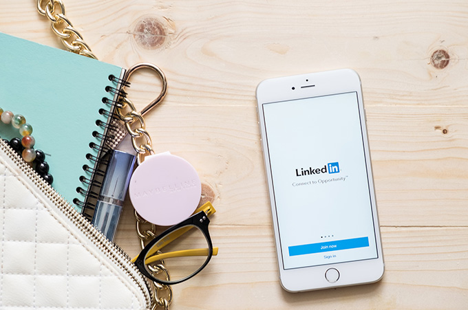 Accesorios Femeninos Junto a Smartphone con Aplicacin de Linkedin en su Pantalla