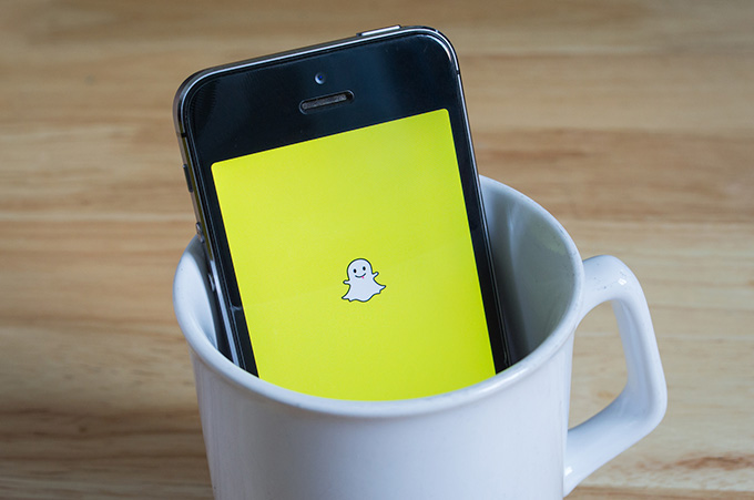 Smartphone, Dentro de Taza de Caf Blanca, que Muestra Snapchat en su Pantalla