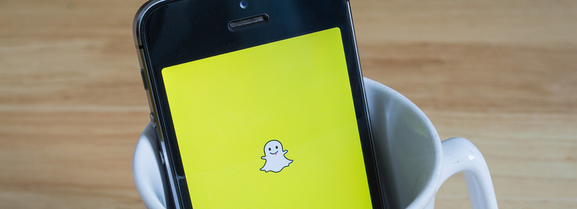 Smartphone, Dentro de Taza de Caf Blanca, que Muestra Snapchat en su Pantalla