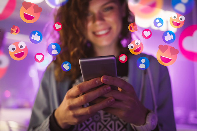 Mujer Joven Sonriente que Mira Pantalla de su Smartphone con Muchos conos Alrededor