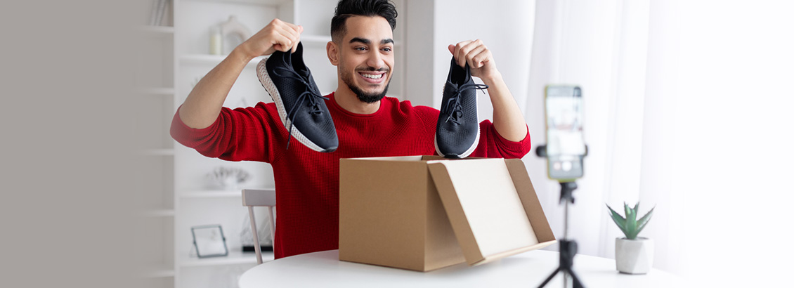 Chico Influencer Frente a Cmara de Smartphone Mientras Hace Unboxing de Zapatillas