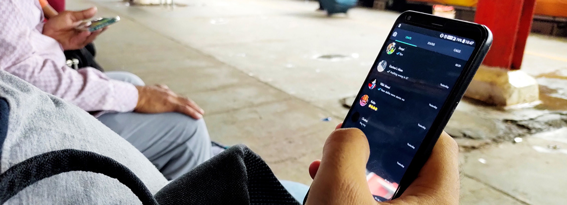 Persona Revisando sus Conversaciones de WhatsApp en Smartphone