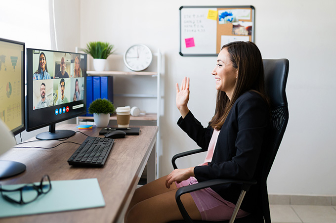Chica Sentada Frente a Pantalla de Computador en Videoconferencia Laboral