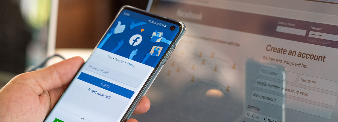 Persona con Facebook Abierto en su Smartphone y en su Laptop