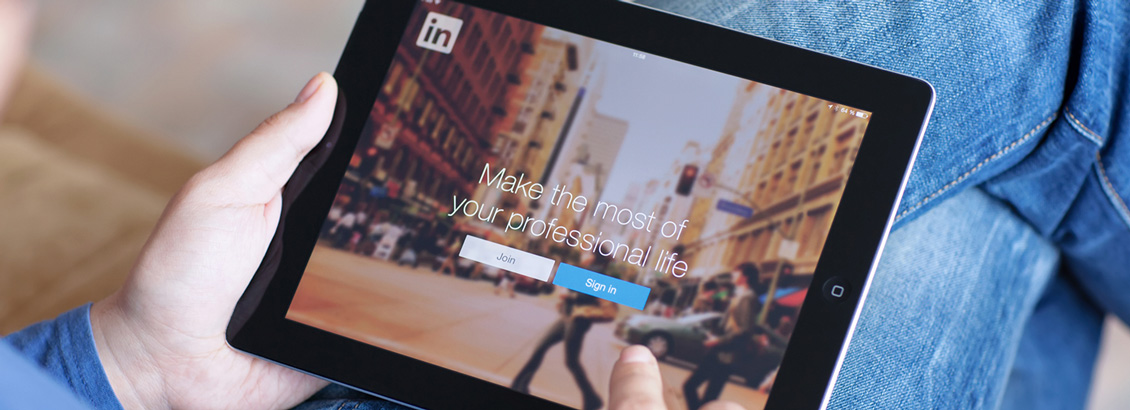 Persona Sosteniendo Tablet a Punto de Iniciar Sesión en LinkedIn