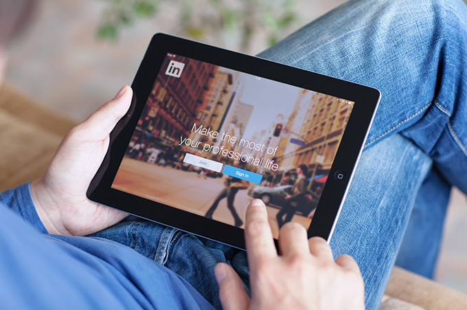Persona Sosteniendo Tablet a Punto de Iniciar Sesin en LinkedIn