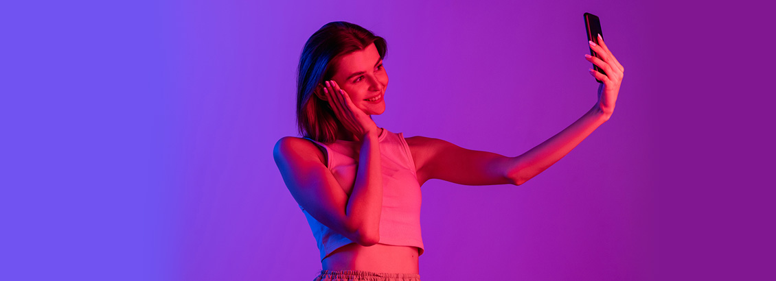 Chica Influencer Bajo Luces de Nen Mientras Toma Selfie con Smartphone