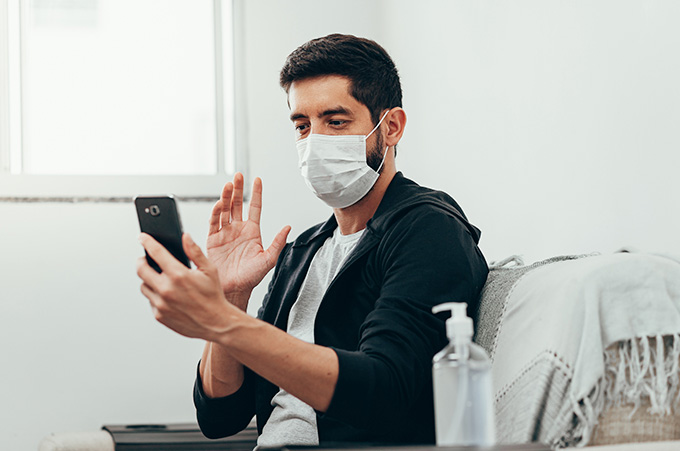 Influencer con Tapabocas Grabando un Video en su Smartphone