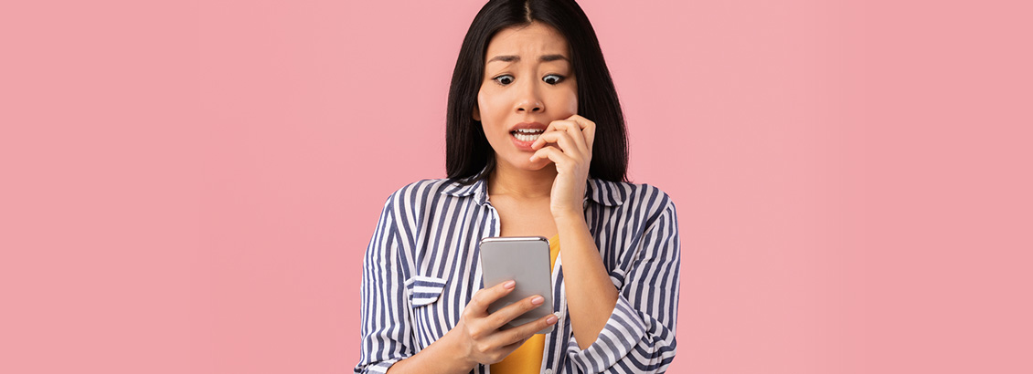Chica con Cara de Preocupación Mientras Mira Metida de Pata en su Smartphone