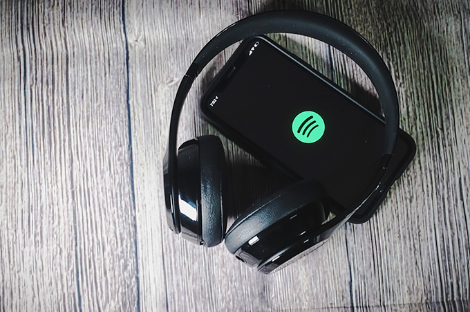 Audfonos Encima de Smartphone con el Logo de Spotify en la Pantalla