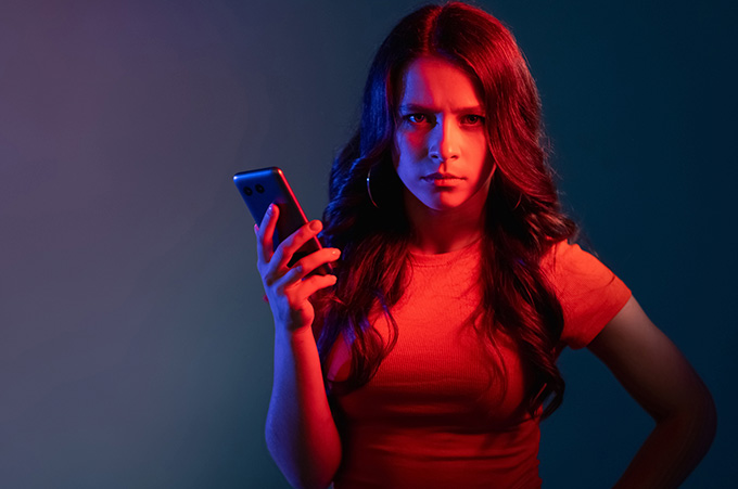 Chica Hater Haciendo Gesto Enojado Mientras Escribe Comentario Negativo en Smartphone