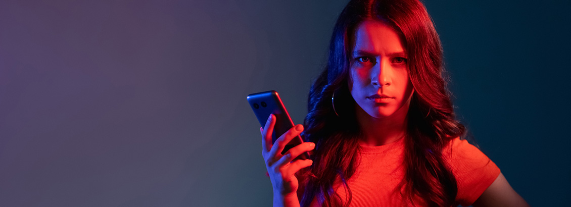 Chica Hater Haciendo Gesto Enojado Mientras Escribe Comentario Negativo en Smartphone