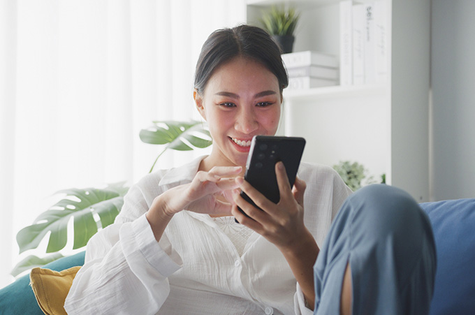 Mujer Sonriente Revisando Publicaciones en Instagram