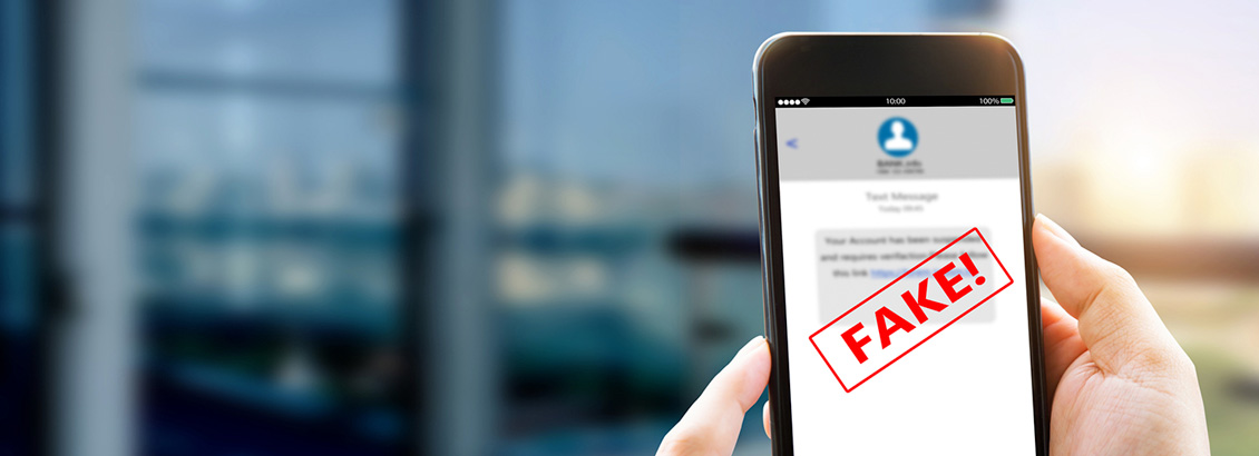 Mano Sostiene Smartphone que Muestra Perfil Falso en su Pantalla y Dice Fake