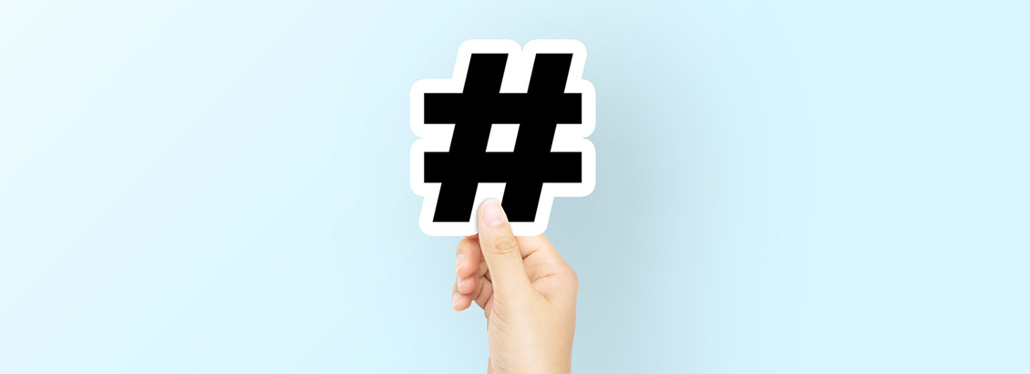 Mano Sosteniendo Hashtag (Etiqueta) Sobre Fondo Celeste