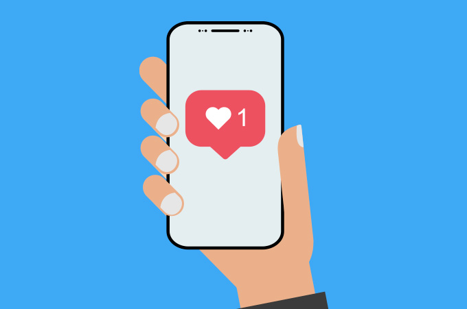 Mano Sosteniendo Smartphone y Mostrando cono de Like de Instagram
