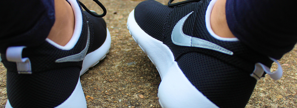 Par de Pies Luciendo Zapatos Tennis con el Logo de Nike