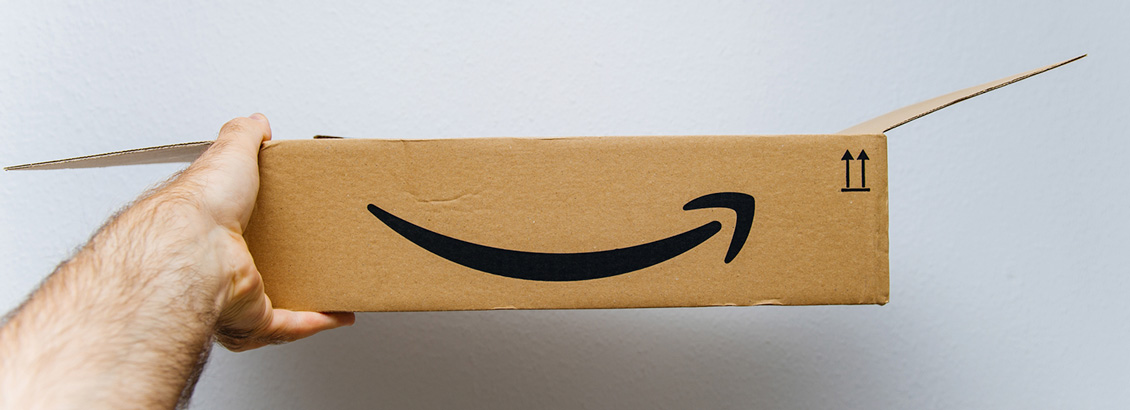 Mano Sosteniendo Caja Abierta con Logo de Amazon