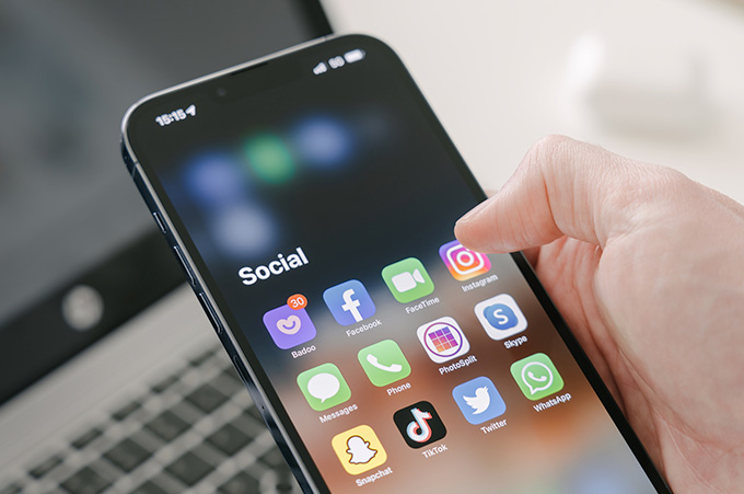 Mano Sosteniendo Smartphone que Muestra Apps de Instagram y WhatsApp en Pantalla