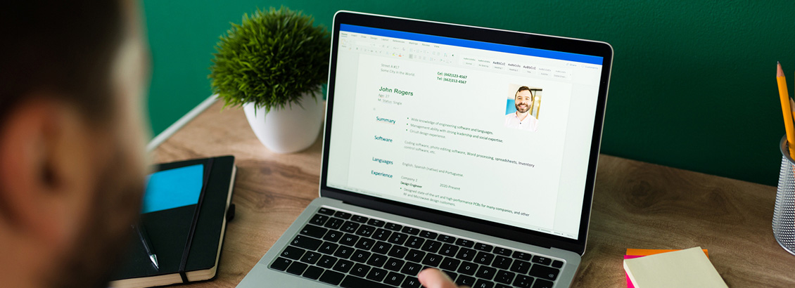 Hombre Revisando su CV en Laptop