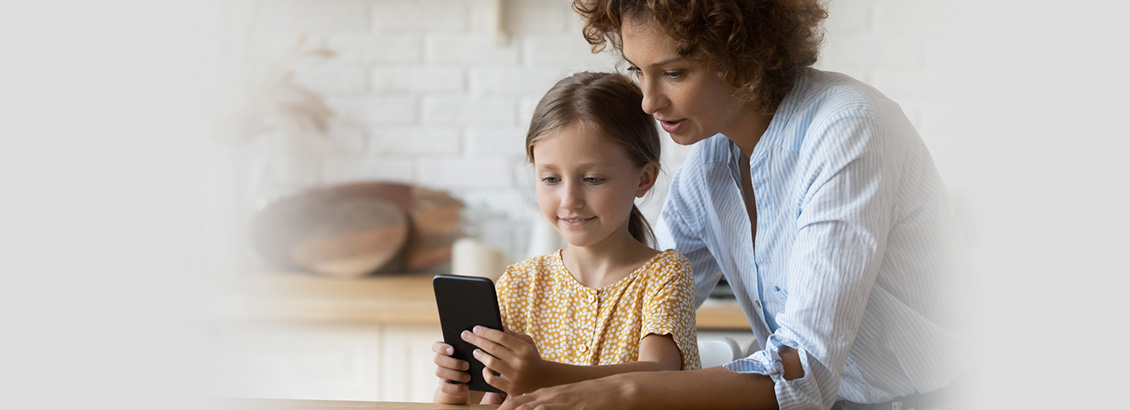 Madre Supervisando a Hija Mientras Navega en Redes Sociales con su Smartphone