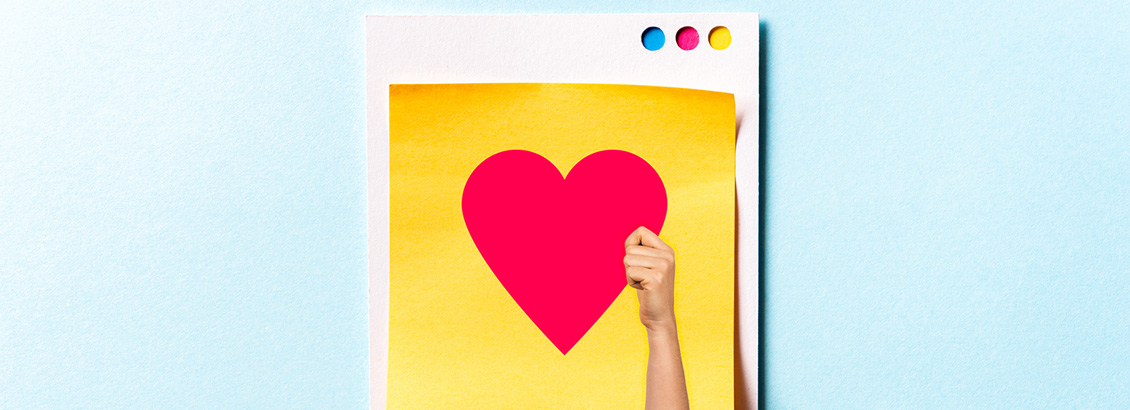 Mano que Sostiene Corazn Rojo Sobre Hojas de Papel Amarillo y Blanco