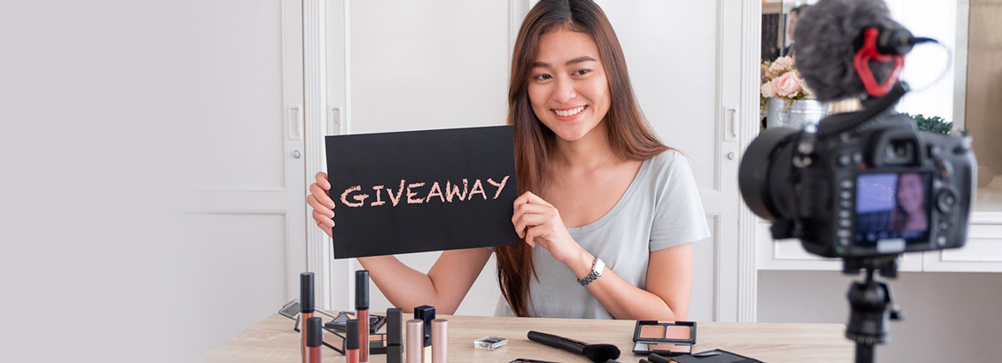 Mujer Sonriente que Sostiene Hoja que Dice Giveaway Frente a Cámara de Smartphone