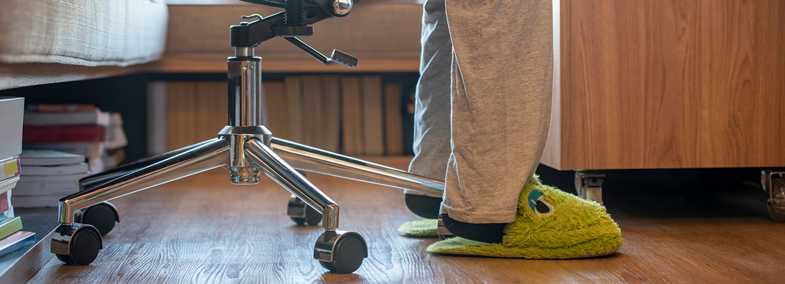Toma Cercana de Pies de Persona con Pantuflas y Silla de Trabajo
