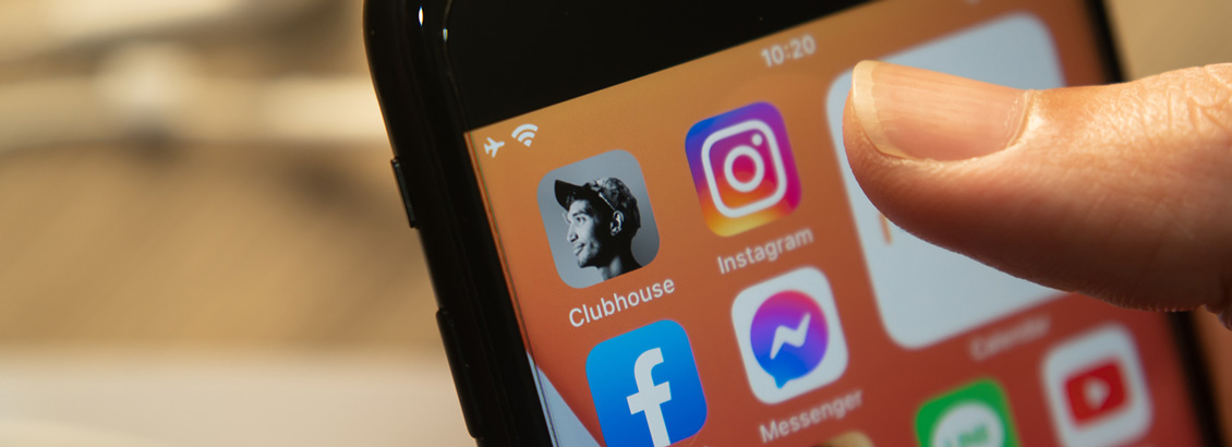 Dedo Presionando Ícono de Instagram en Pantalla de Smartphone