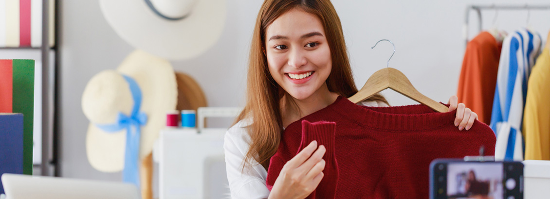 Mujer Sonriente Mostrando Prenda de Ropa en la Cmara de su Telfono
