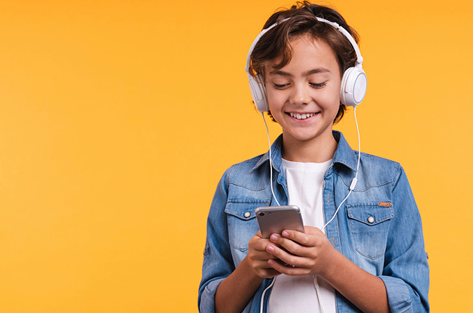 Nio con Audfonos Mirando Instagram en su Telfono